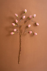 Decorative hairpin with pink floral tips on a brown background