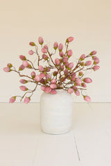 White vase with pink flowers on a light surface