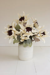 Bouquet of white flowers in a white vase on a light background