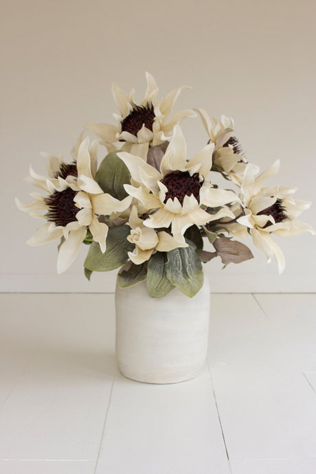 Bouquet of white flowers in a white vase on a light background