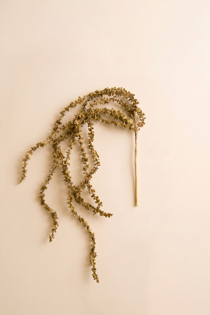 Long trailing greenery and softly textured stems give this faux botanical spray an organic cascading look.