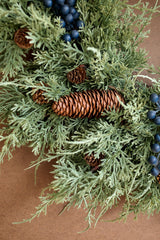 close-up view of evergreen wreath, pine cones and berries