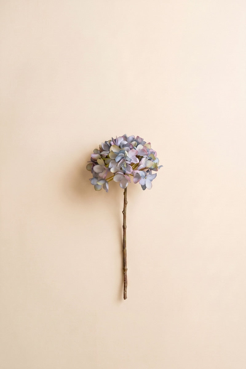 This faux floral stem showcases delicate blue and lavender-toned clustered blooms