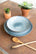 ceramic bowl on top of plate in faded blue color on table - angled view