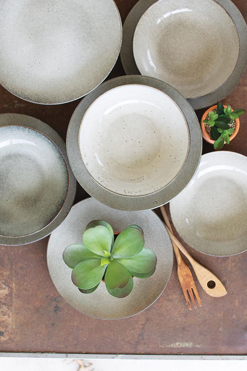 several pairs of ceramic plates and bowls in oatmeal color on top of each other - top down view 2