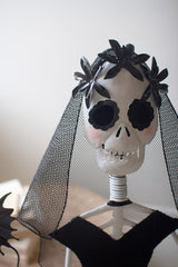 Skull with black flowers and a veil on a white background