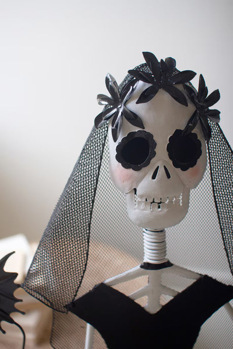 Skull with black flowers and a veil on a white background