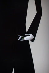 Mannequin arm wearing a black sleeve with a white glove