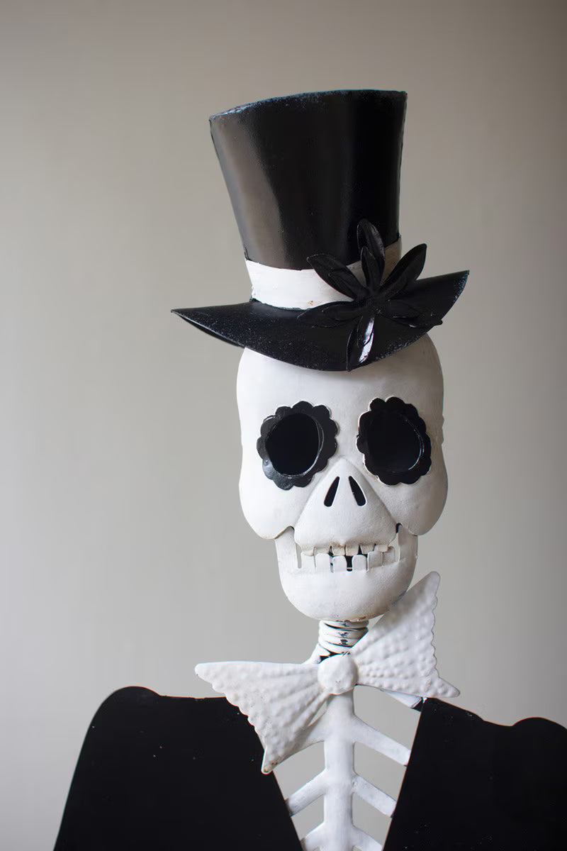 Skeleton wearing a black top hat and bow tie against a plain background