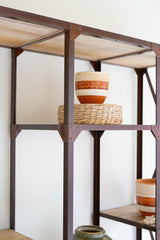 Metal shelving unit with decorative bowls on a white wall