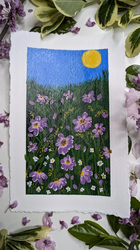 acrylic painting study of purple blossoms on green meadow against blue sky and bright sun