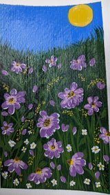 acrylic painting study of purple blossoms on green meadow against blue sky and bright sun - close-up view