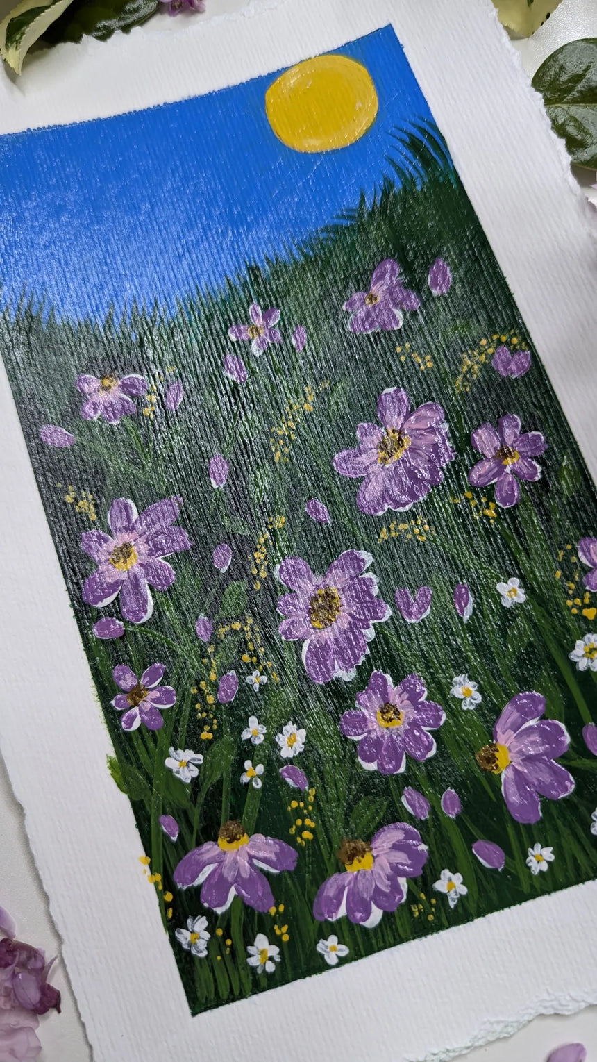 acrylic painting study of purple blossoms on green meadow against blue sky and bright sun - slanted left view