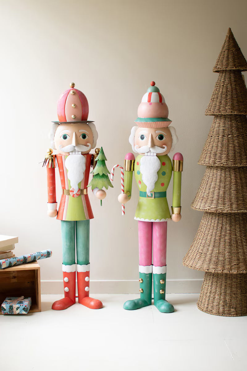 Two colorful nutcrackers standing next to a woven Christmas tree on a light background