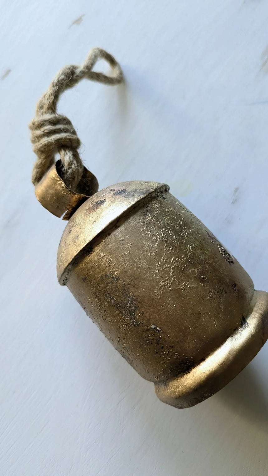 Bronze bell with a string on a white background