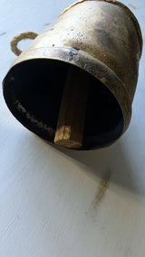 Vintage-style bell with a wooden striker on a white surface