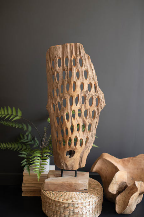 Wooden sculpture with geometric cutouts on a dark background