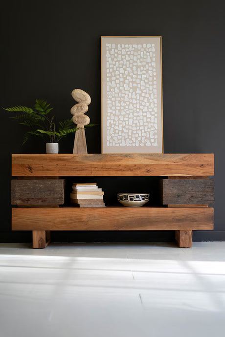 Wooden console table with decorative items against a dark wall