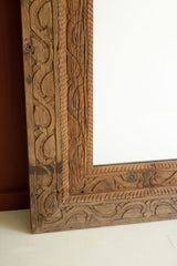 Wooden frame with intricate carvings standing on a white surface