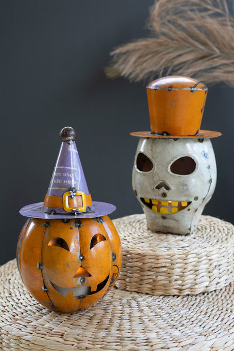 Two Halloween-themed decorative items one orange pumpkin with purple witch hat and a skull with orange top hat
