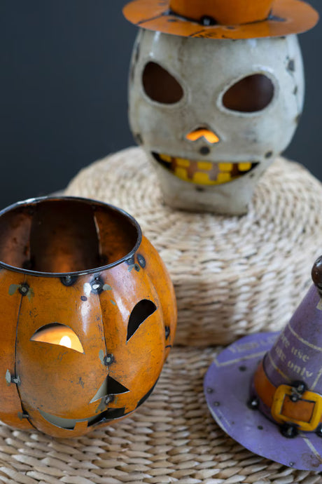 Halloween-themed decorations including a skull, jack-o'-lantern, and witch hat on a textured surface.