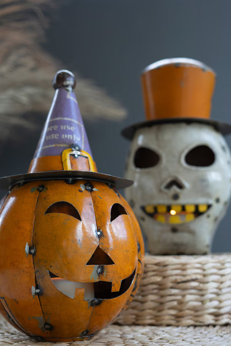 Decorative pumpkin with a top hat and skull in the background