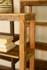 Wooden shelf with books and a decorative item in a softly lit room - close-up of wood top and right edge