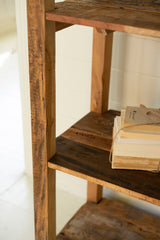 Wooden shelf with books on a white wall background - close-up downward angle view of left side of shelf