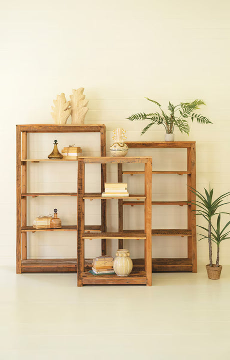 Set of 3 wooden bookshelves of varying heights with decorative items against a light wall