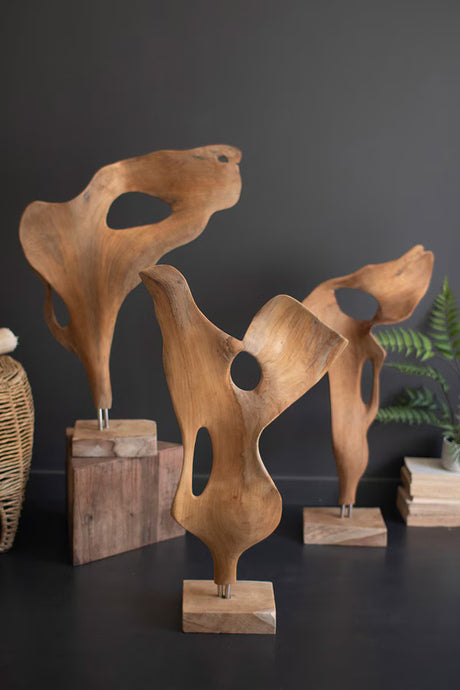 Wooden abstract sculptures on a dark surface with a dark gray background
