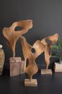 Wooden abstract sculptures on a dark surface with a dark gray background