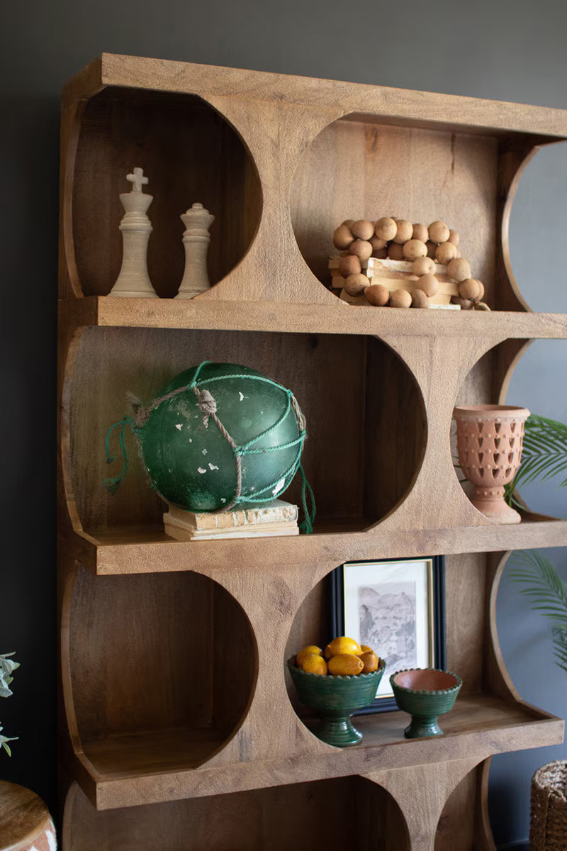 Wooden shelf with decorative items against a dark wall - angled zoomed view