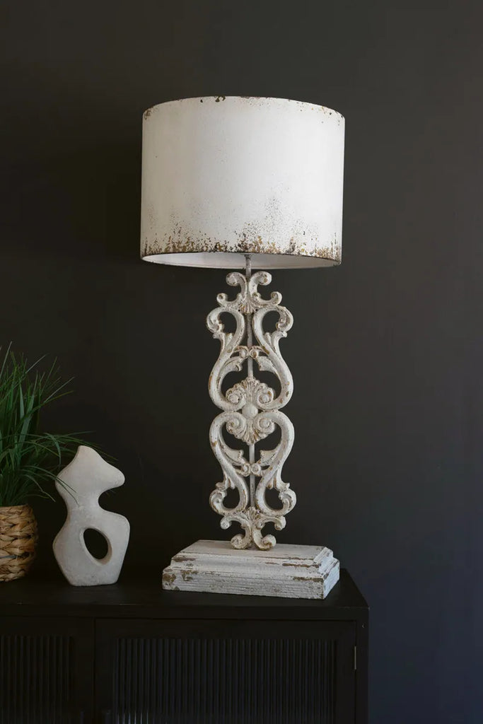 antique white table lamp with damask base standing atop a dark brown console