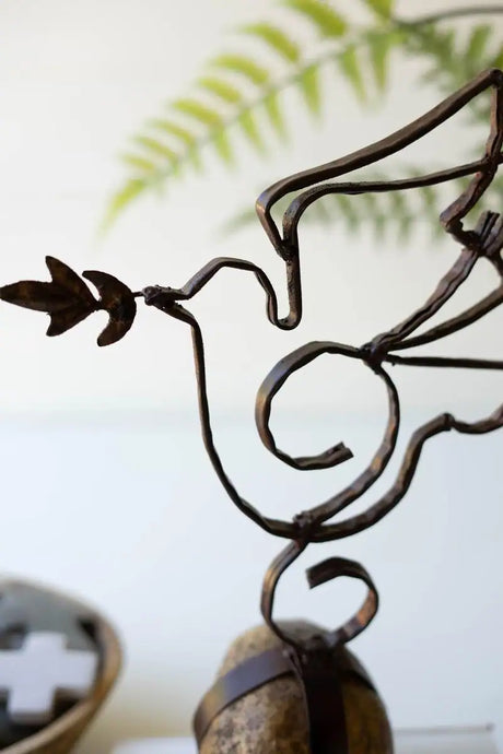 close up of metal dove and its olive branch