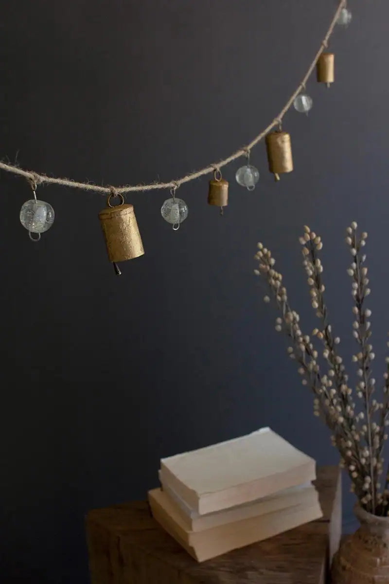 garland hanging against dark backdrop above a shelf with books