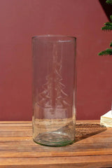 empty glass cylinder with christmas tree design on the side