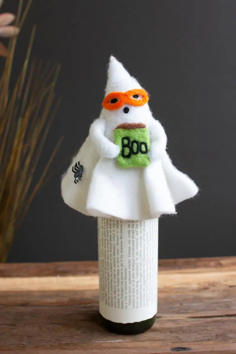 felt ghost wine topper with orange glasses a book labeled boo and a spider