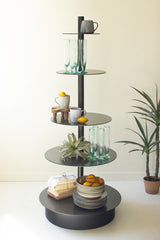 Round, black 5-tiered shelf with decorative items against a white wall