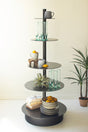 Round, black 5-tiered shelf with decorative items against a white wall