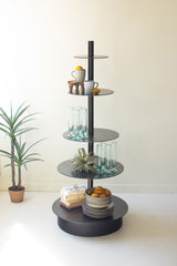 Black 5-tiered retail display shelf with decorative items on a white surface