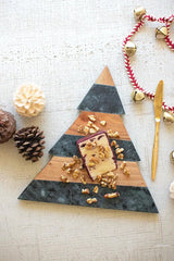 triangular wood and green marble cutting board shown with some cheese and nuts