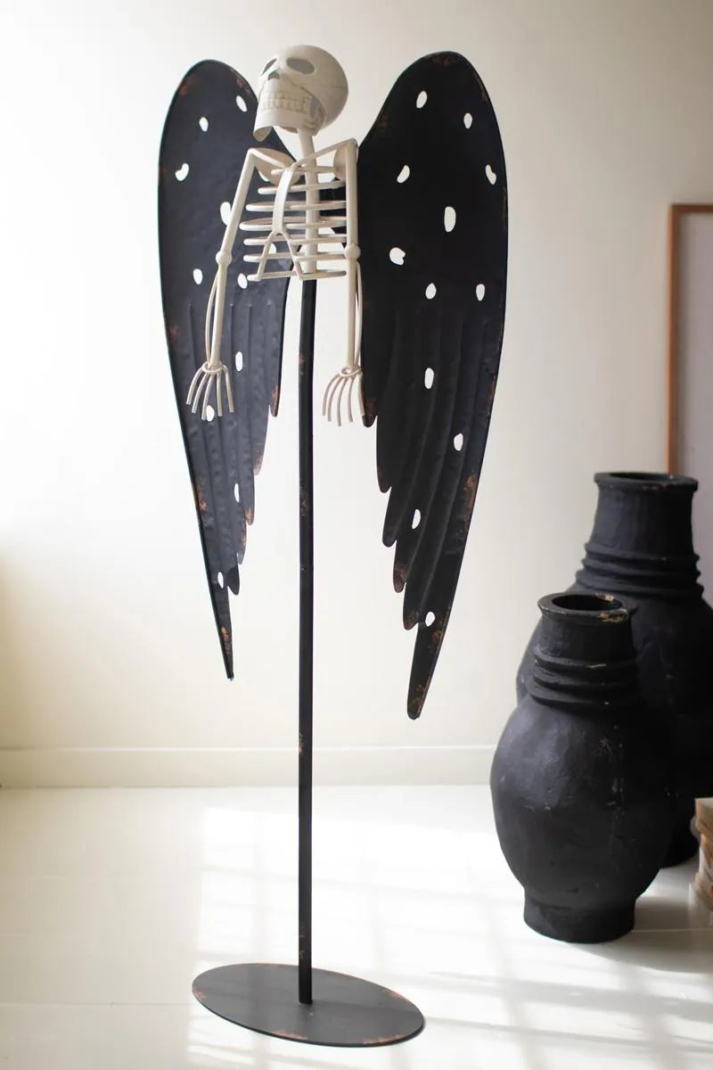 white skeleton with black wings on a black stand