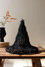 black twig witch's hat shown sitting on a wood table