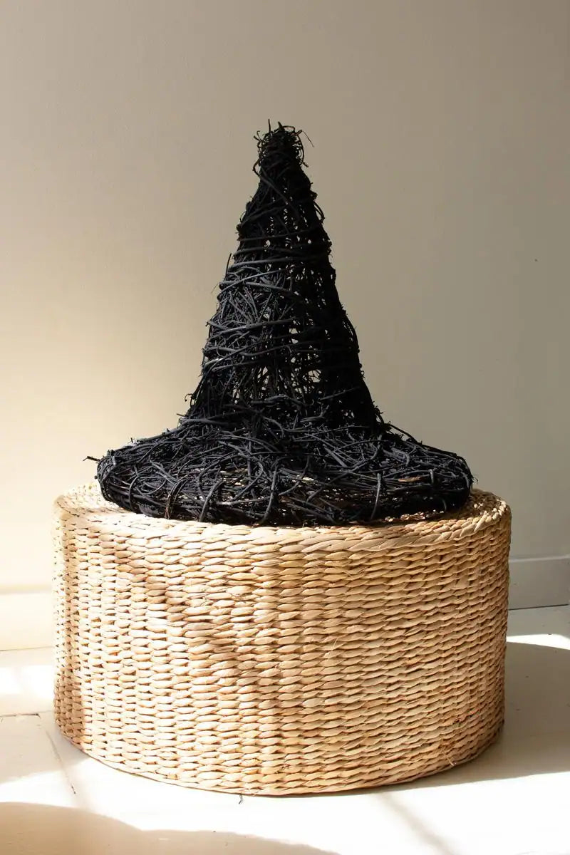 black twig witch's hat shown sitting on a round wicker basket