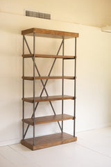 Thick pine wood bookshelf with metal frame against a white wall at an angle