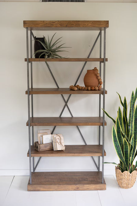 Wooden bookshelf with decorative items against a white wall