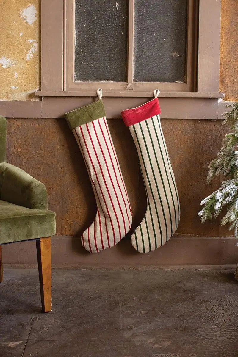 2 white christmas stockings with vertical stripes red and green and the opposite color velvet collar