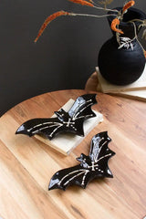 alternate view of black ceramic bat platters with black vase on wooden table