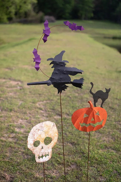 flying witch and bats, black cat on an orange pumpkin and skeleton head yard stakes now shown on a green lawn