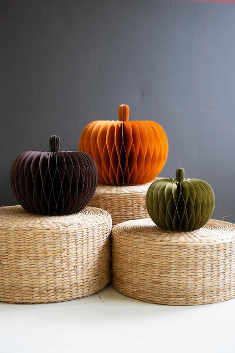 accordian pumpkins in orange, dark violet red and dark green sitting on baskets